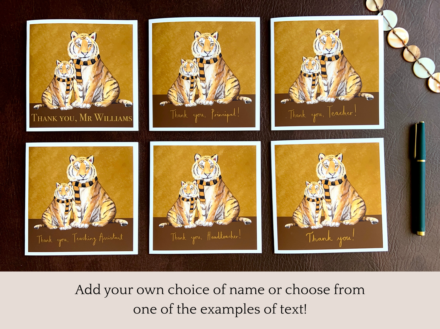 Premium thank you teacher card featuring illustrated tigers wearing black and amber scarves shown in six personalised text options laid flat on a leatherette surface. Variations include ‘Thank you, [Custom Name]’, ‘Thank you, Teacher!’, ‘Thank you, Teaching Assistant’, ‘Thank you, Headteacher’, ‘Thank you, Principal!’ and ‘Thank you!’. Infographic text explains you can add a custom name or choose from examples. Ideal end of term teacher appreciation card printed on thick 312gsm fine art card by a UK artist