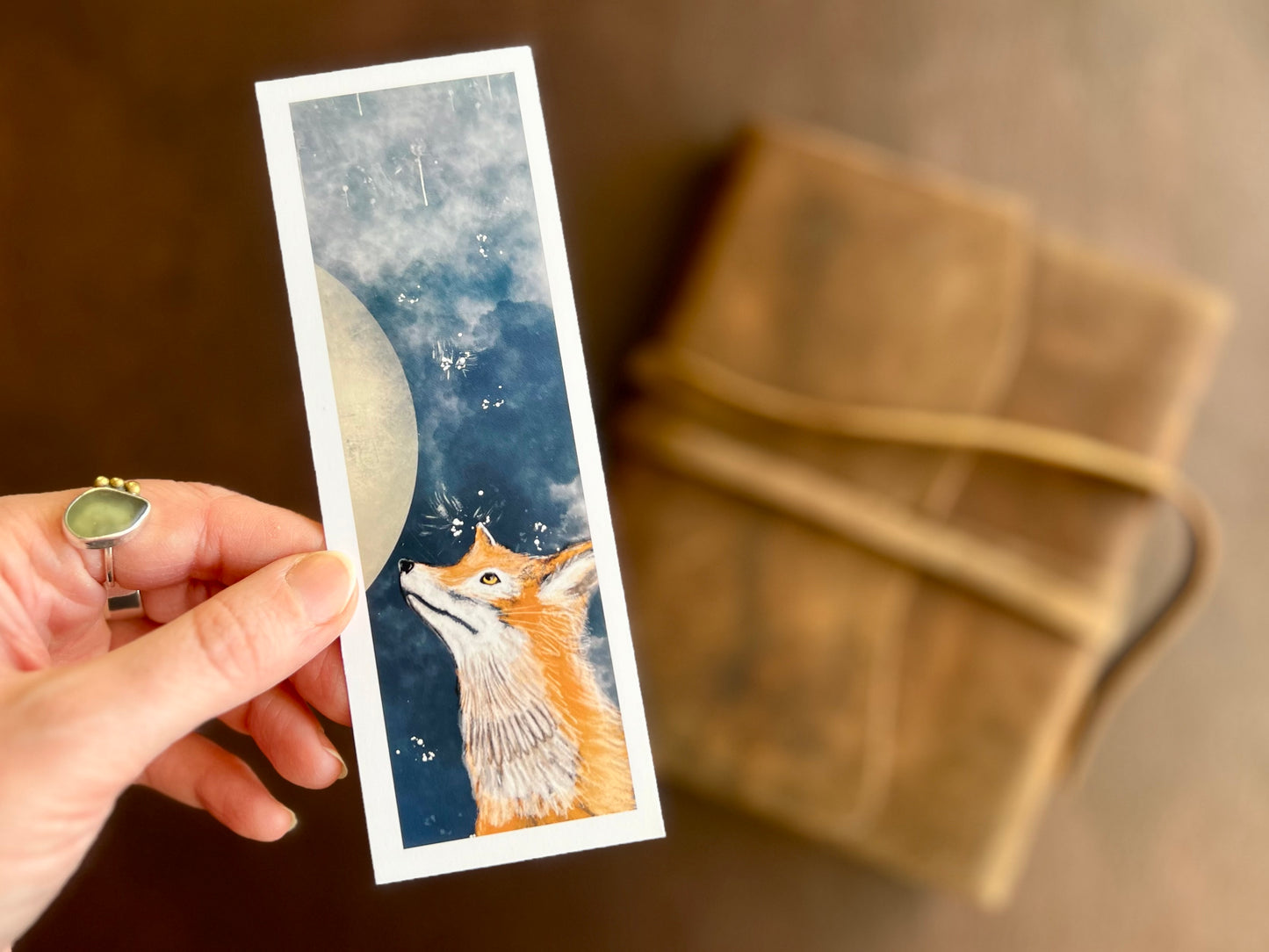 Close up of an illustrated fox and moon bookmark by UK artist Hayley Victoria. Small stocking filler gift from independent business.