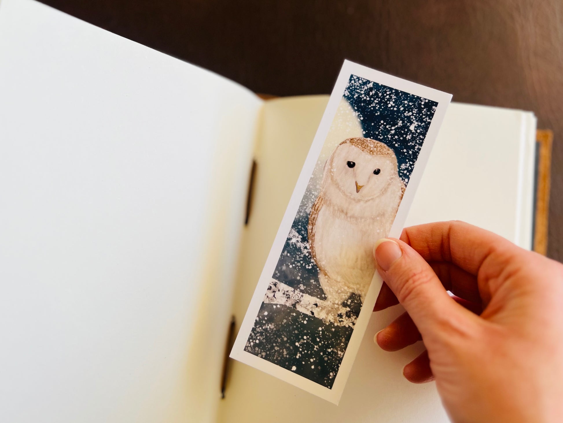 Lovely stocking filler gift for book lovers. This photo shows this illustrated bookmark being placed into a blank sketchbook. 