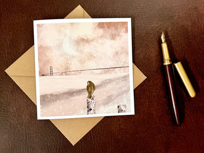 Greeting card showing the Humber Bridge in a winter landscape with a soft pink sepia tone, part of an East Yorkshire themed design featuring a robin by the river.