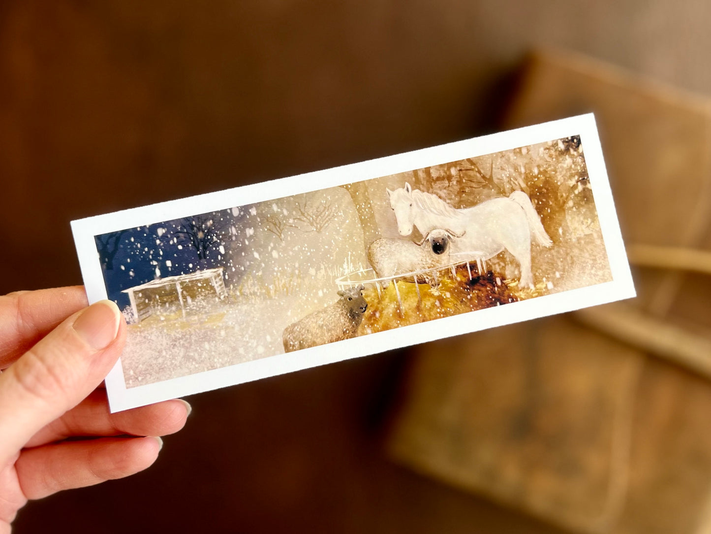 A beautiful bookmark featuring an illustration of a white horse and two sheet on a snowy winter’s night. Artisan gift for reading lovers, stationery lovers and lovers of small pieces of art.
