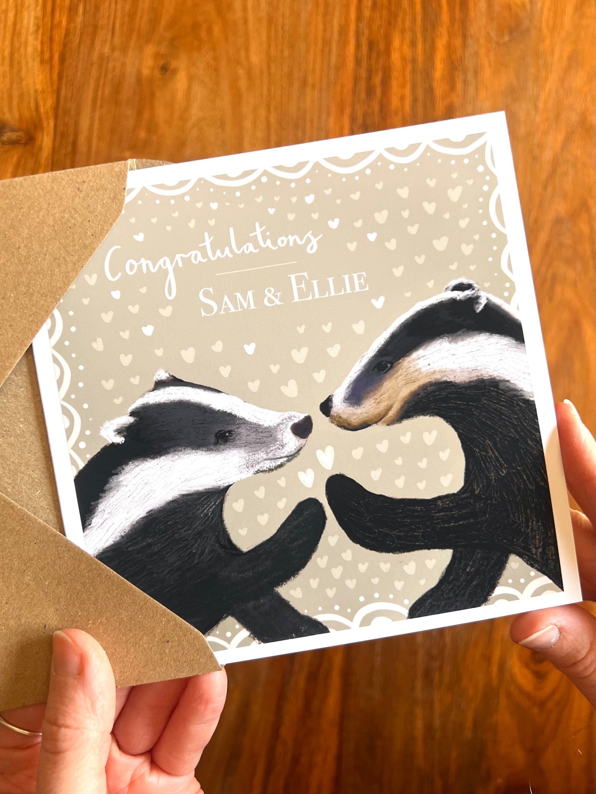 Personalised engagement card with badger illustration being removed from recycled kraft envelope, congratulations [Name] & [Name], rustic woodland design suitable for Mr & Mr, Mrs & Mrs or Mr & Mrs couples and ideal for son and daughter in law, daughter and son in law etc.