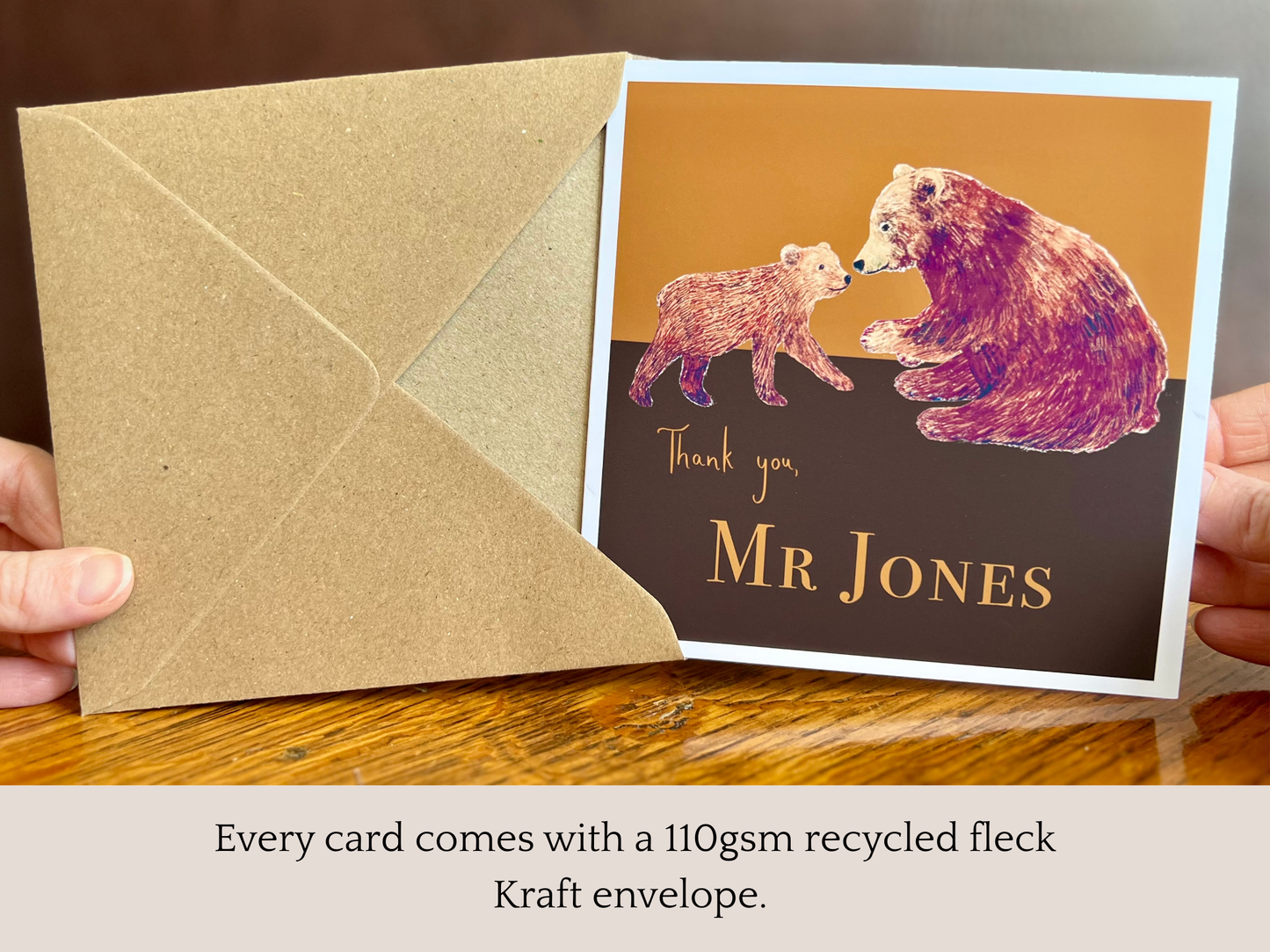 Special personalised thank you card featuring a brown bear and bear cub illustration being removed from its recycled fleck kraft envelope and held up to the camera. Infographic text highlights that every card includes a 110gsm recycled fleck kraft envelope. Custom name design suitable as a thank you teacher card, end of school year appreciation card, teaching assistant thank you card or personalised thank you card for any recipient. Printed on thick 312gsm fine art card by a UK independent artist.