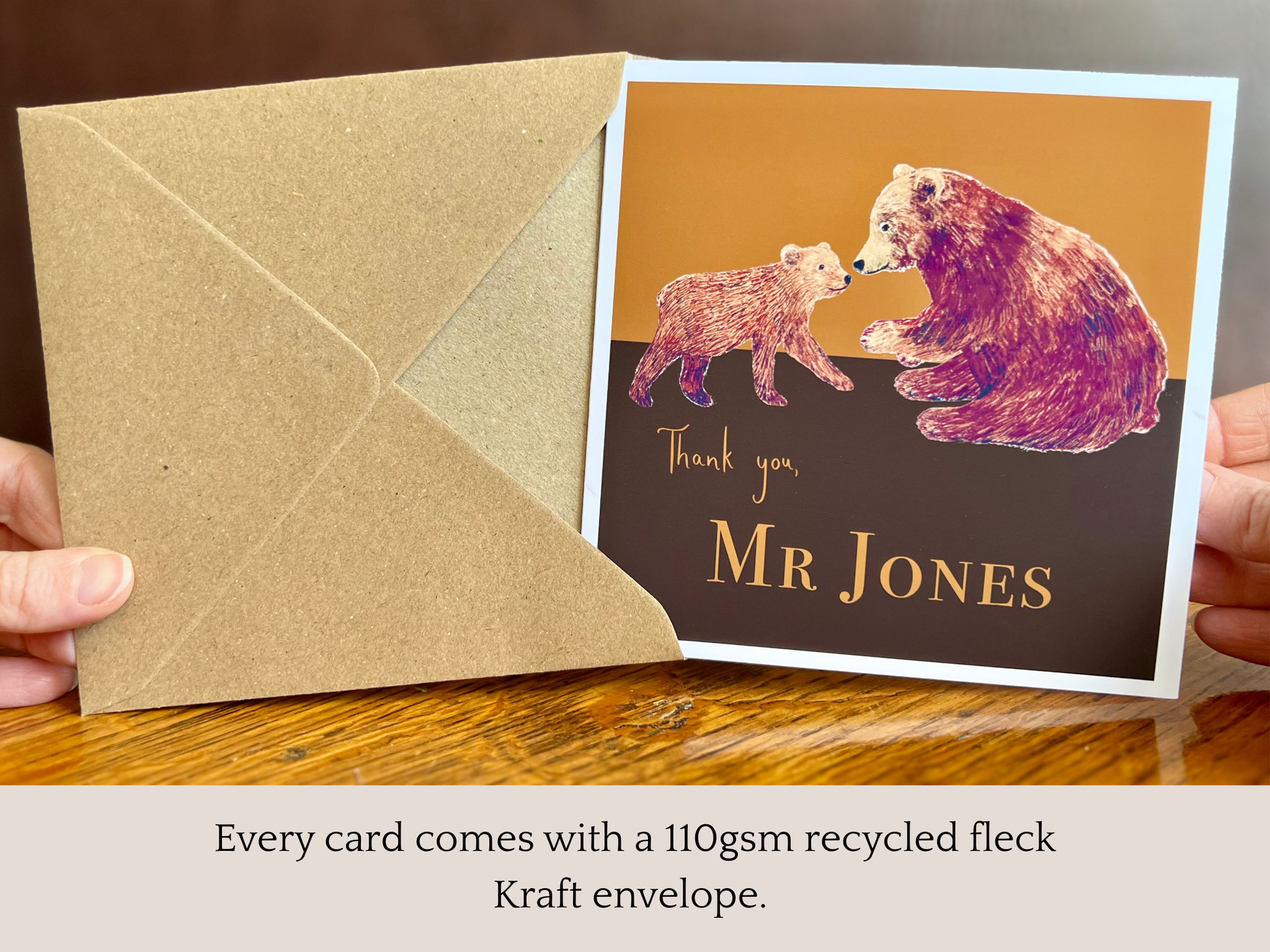 Special personalised thank you card featuring a brown bear and bear cub illustration being removed from its recycled fleck kraft envelope and held up to the camera. Infographic text highlights that every card includes a 110gsm recycled fleck kraft envelope. Custom name design suitable as a thank you teacher card, end of school year appreciation card, teaching assistant thank you card or personalised thank you card for any recipient. Printed on thick 312gsm fine art card by a UK independent artist.