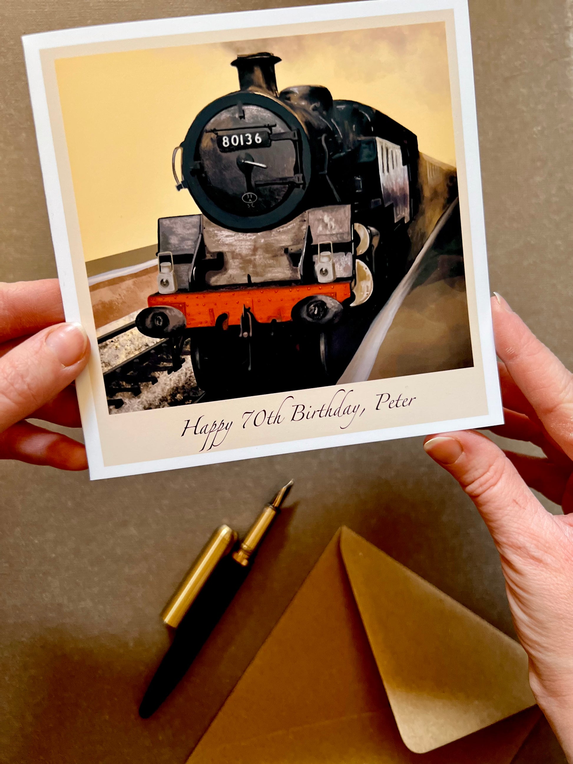View of personalised birthday card featuring steam train engine 80136. Blank inside suitable for writing a message, with branding printed on the back.
