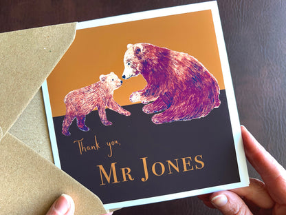 Premium personalised thank you teacher card featuring an illustrated adult brown bear and bear cub against a dark brown and burnt orange background. Example design shown with the text ‘Thank you, Mr Jones’, demonstrating custom teacher name personalisation. Ideal end of term or end of school year thank you card for male or female teachers. Printed on thick 312gsm fine art card by a UK independent artist and supplied with a recycled kraft envelope.
