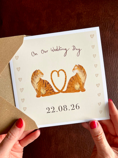 Hands holding a personalised wedding day card for partner featuring two illustrated tigers with tails forming a heart and custom wedding date beneath the illustration