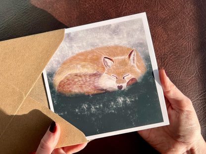Premium illustrated art card featuring a sleeping fox in a calm woodland scene, set against a textured dark green and grey background. Versatile greeting card suitable for any occasion, showcasing peaceful wildlife illustration and fine art design.