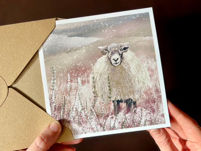 Premium illustrated Christmas greeting card featuring a Swaledale sheep standing in a snowy Yorkshire Dales countryside landscape. Festive winter scene design inspired by rural wildlife and British countryside at Christmas.