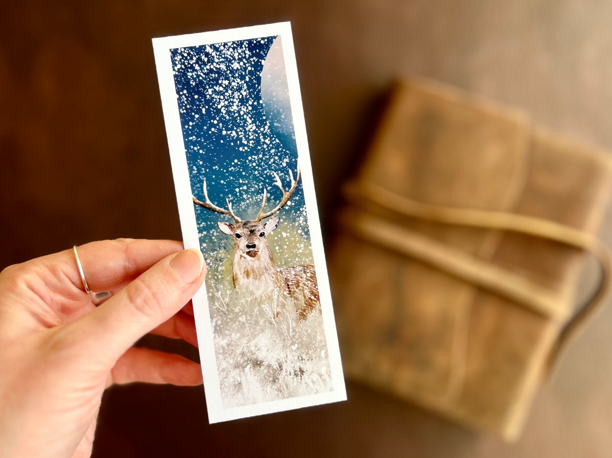 Artisan bookmark featuring deer illustration in front of a celestial moon and snowy night sky.