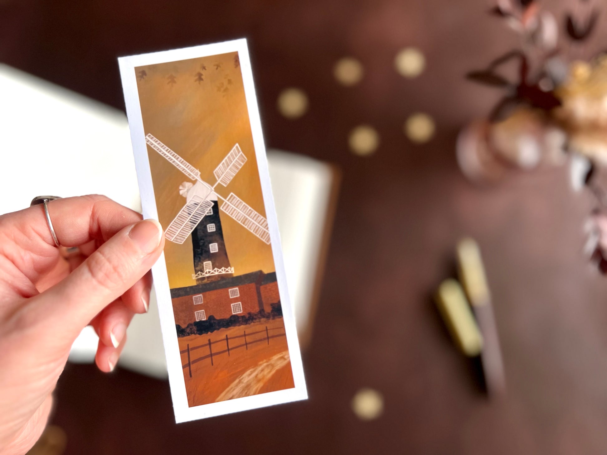 Skidby Windmill bookmark shown with a fountain pen and open sketchbook on a cosy dark academia inspired writing desk with warm autumn tones.
