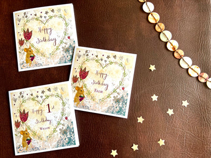 Flat lay image showing three artisan birthday card design variations featuring an illustrated mouse holding a blackberry with red collage style flowers and a floral heart on a lemon yellow background. The versions display 'Happy Birthday', 'Happy Birthday' with a custom name, and 'Happy [age] Birthday' with a custom name for personalisation options.