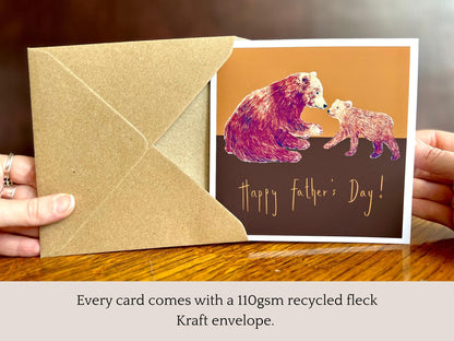 Infographic showing an artisan Fathers Day card featuring a brown bear and bear cub on a warm brown and burnt orange background being removed from a kraft envelope, with text explaining that every card comes with a 110gsm recycled fleck kraft envelope.
