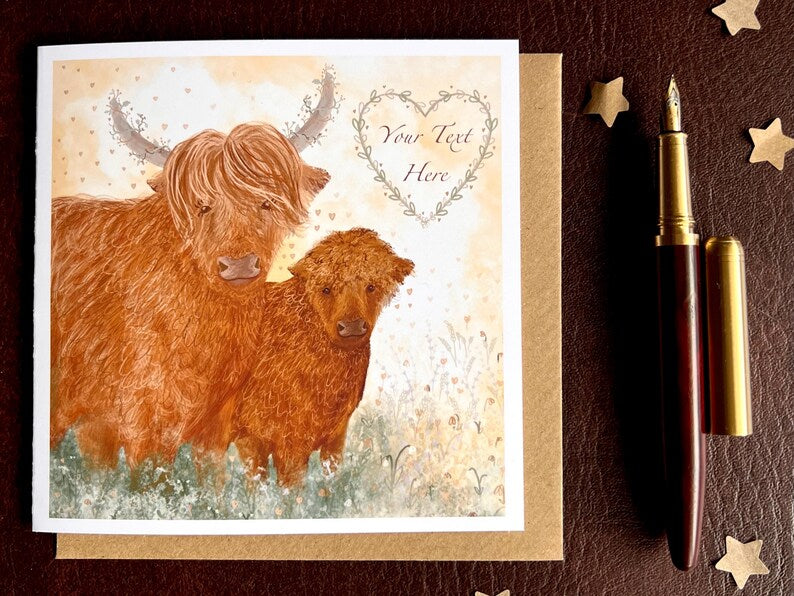 Flat lay image of an artisan greeting card featuring two Highland cows on a lemon yellow background, shown laid flat on a tabletop with its kraft envelope and a pen. The floral heart contains the text 'Your Text Here' to demonstrate customisation options.