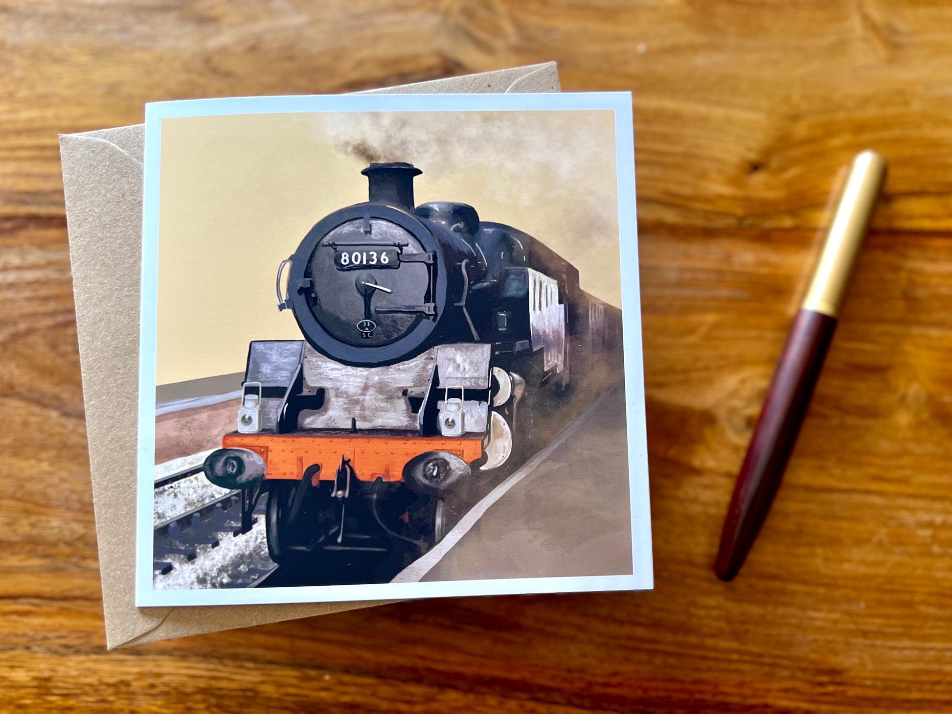 Special illustrated greeting card featuring steam engine 80136 from the North Yorkshire Moors Railway on a yellow background, laid flat on a wooden tabletop. Heritage railway art card design suitable for train enthusiasts and steam locomotive lovers.