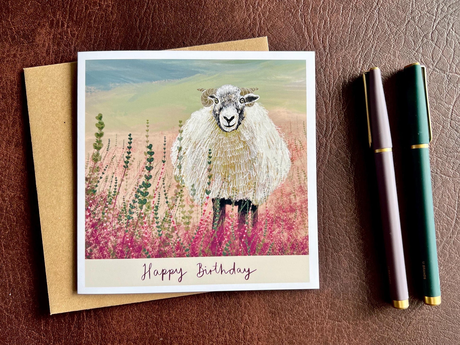 Special illustrated birthday greeting card featuring a Swaledale sheep standing in a heather landscape on the Yorkshire moors, laid flat for display. The design includes the text “Happy Birthday” beneath the illustration, inspired by rural countryside wildlife art.
