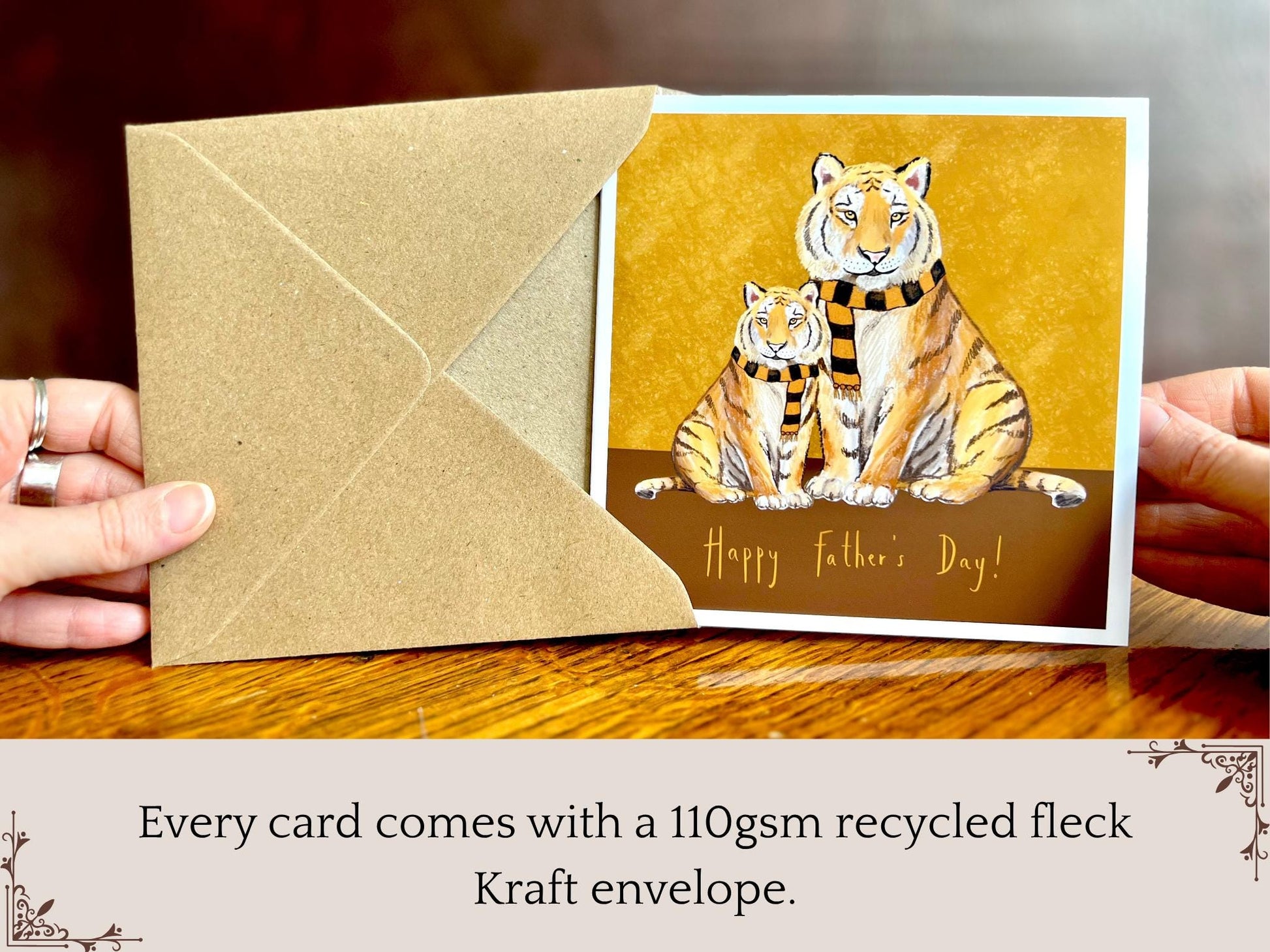 Premium Father’s Day card featuring an illustrated adult tiger and younger tiger wearing black and amber scarves against a dark brown and burnt orange background. The design reads ‘Happy Father’s Day!’ and is shown in an infographic layout highlighting that each card comes with a 110gsm recycled fleck kraft envelope. Ideal Father’s Day card for dad, grandad, step-dad or father figure. Printed on thick 312gsm fine art card by a UK independent artist.