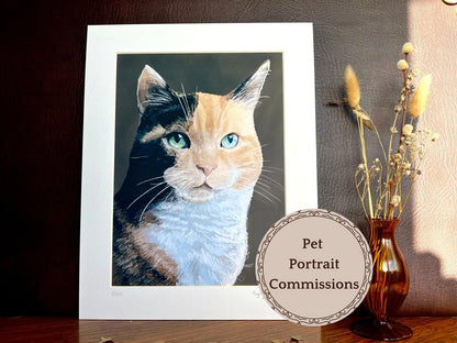 Custom realistic calico cat pet portrait print in 11x14 mount, displayed on desk next to vase of flowers, personalised cat artwork by UK artist