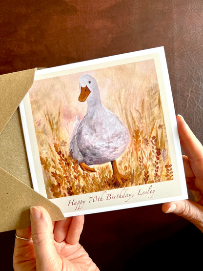 Close-up of Duck in the Meadow birthday card being removed from a recycled envelope, showing personalised milestone text ‘Happy [Age] Birthday, [Name]’ for special birthdays or milestone celebratiUna