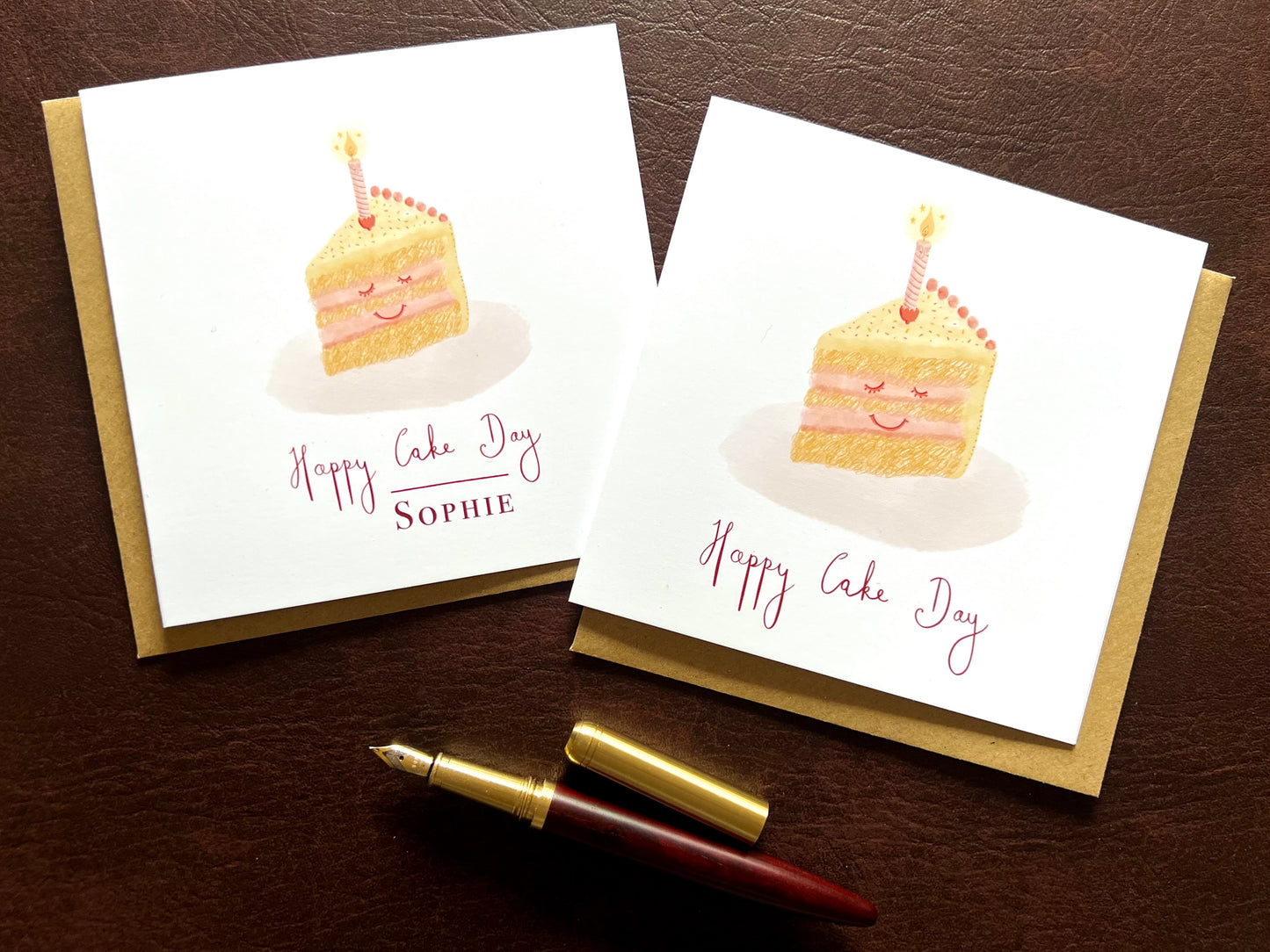 Two Happy Cake Day birthday cards side by side, one personalised with a name and one without, smiling cake illustration with lemon yellow icing and pink candle, UK handmade